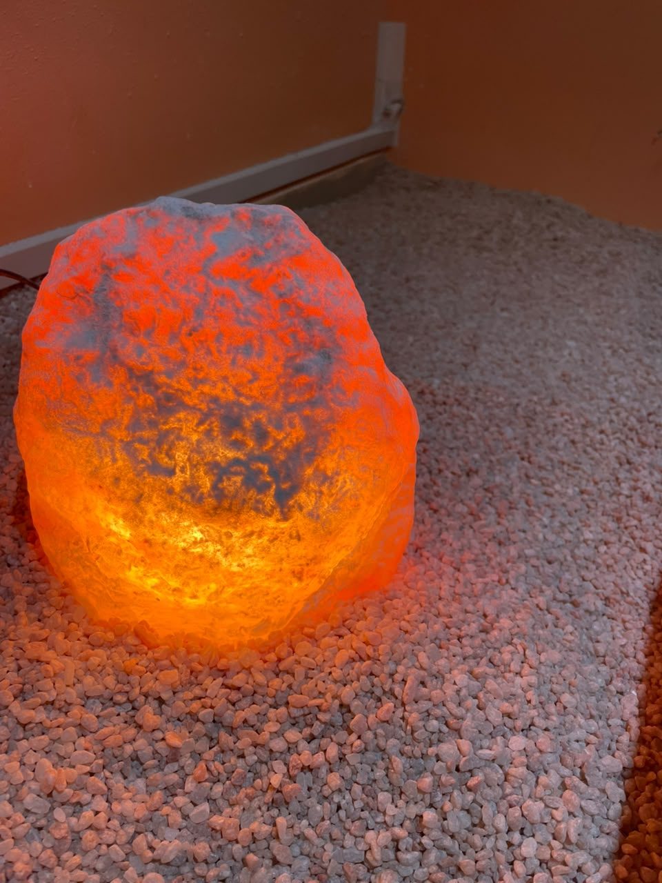 Lámpara de sal encendida sobre el piso de sal